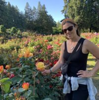 Amanda admires a sherbet rose in the Portland rose garden.